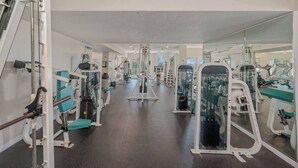 Een sportschool met diverse fitnessapparaten, spiegels en een schoon, modern design.