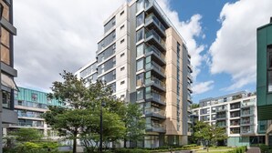 A modern multi-story residential building with balconies, surrounded by greenery and a clear sky. - Clerkenwell Flat Near Old Street Pet Friendly (London)