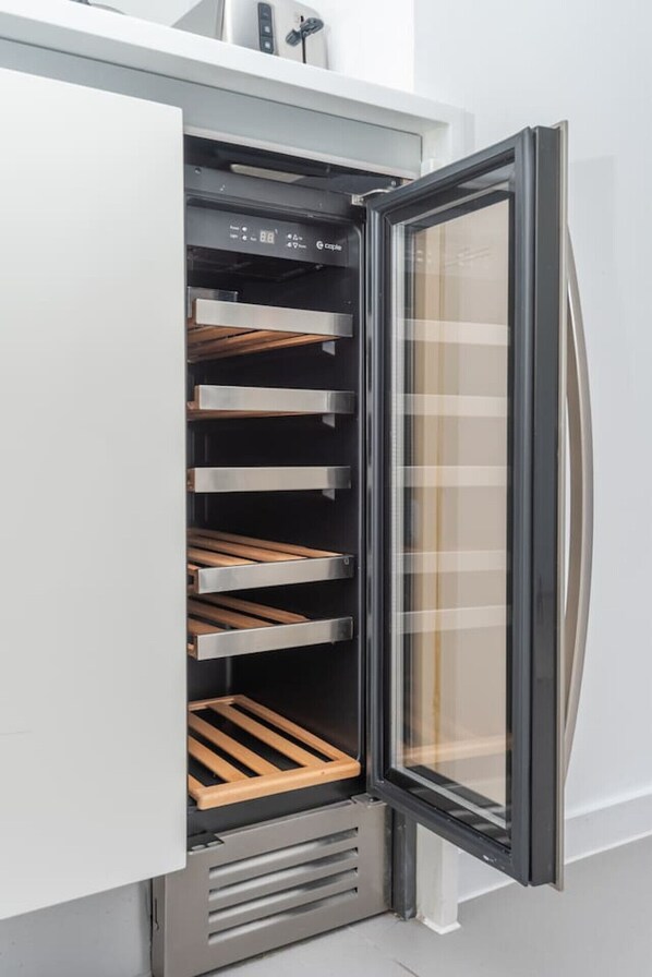 An open refrigerator with multiple shelves and a glass door. - Clerkenwell Flat Near Old Street Pet Friendly (London)