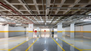 Un parcheggio multipiano con segnaletica chiara, corsie ben delimitate e pavimento pulito e riflettente.