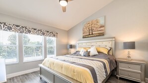 A bedroom with a large bed, a nightstand, a wall-mounted lamp, and a window with blinds. - Pet friendly, upgraded townhouse, with heatable pool, and Jedi themed bedroom (Kissimmee)