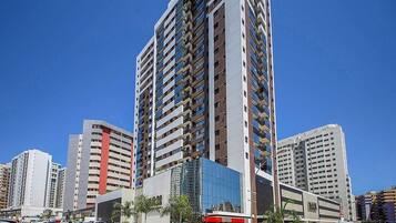 A high-rise building with multiple floors, a modern glass facade, and a commercial ground floor with a visible storefront.