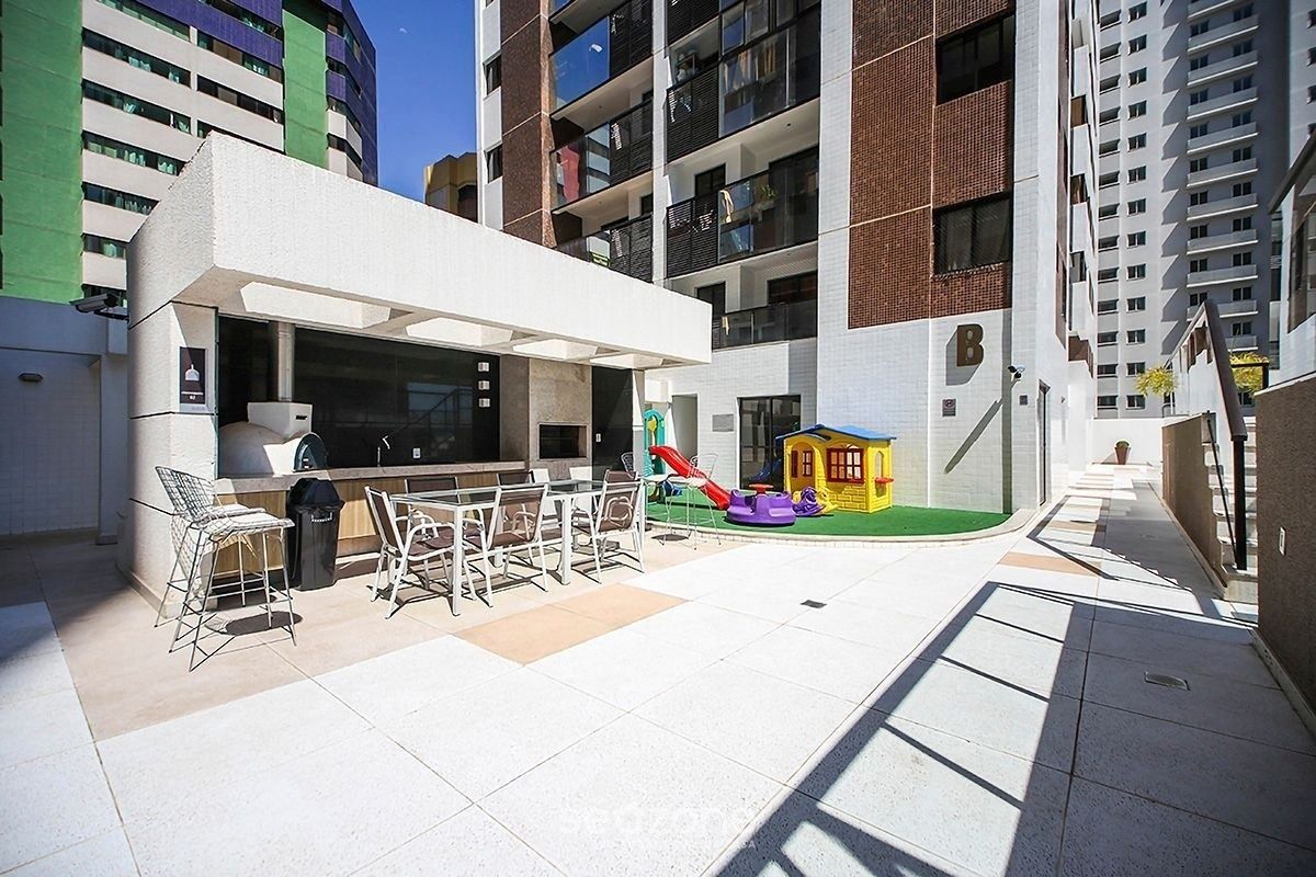 Un patio exterior con zona de estar y equipo de juegos para niños.