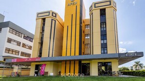 A yellow building with the sign "APEX" on top. - Studio Moderno prox. do Shoppping Iguatemi SHL0105 (Lago Norte)