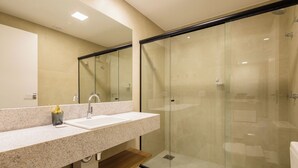 A modern bathroom with a glass-enclosed shower, a large sink, and a mirror. - ENE - Apartments in Noroeste in Brasilia (Brasília)
