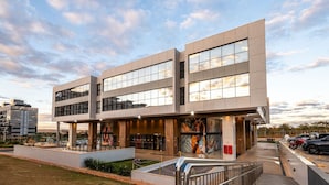 A modern building with a flat roof, large windows, and a central entrance with a ramp. - ENE - Apartments in Noroeste in Brasilia (Brasília)