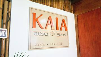 Een bord met 'KAIA SIARGAO VILLAS', met de slogan 'aarde • zee • leven'.