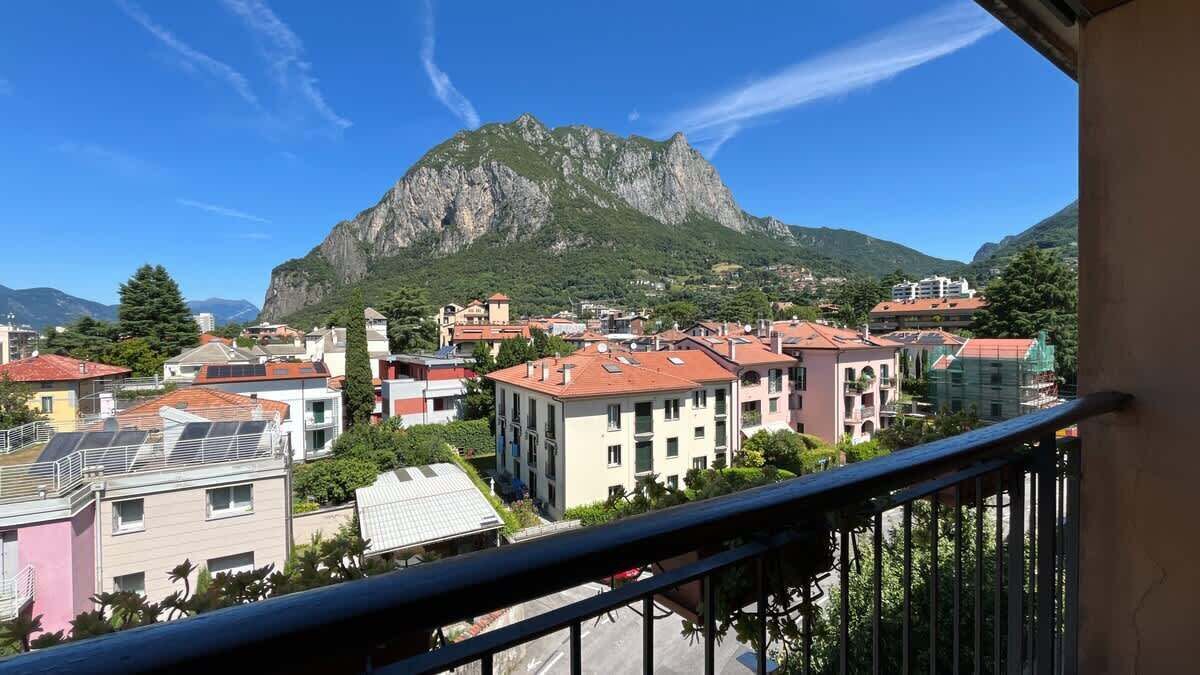 Un quartier résidentiel avec des immeubles, une montagne et un ciel dégagé.