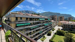 A multi-story hotel with balconies, a courtyard, and mountain views.