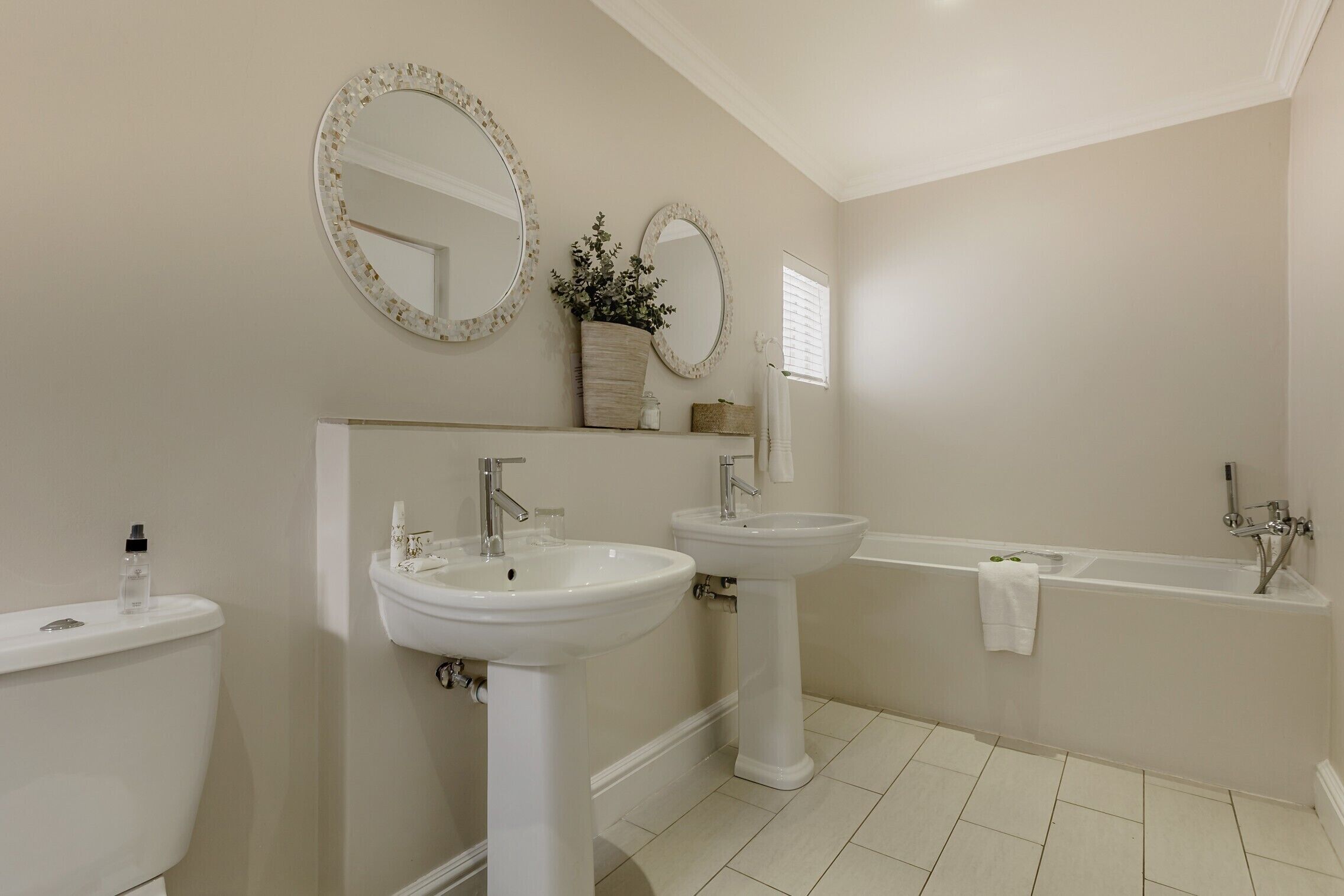 A bathroom with two sinks, a toilet, and a bathtub.