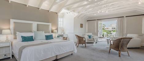 A spacious bedroom with a large bed, a ceiling fan, and a view of the outdoors.