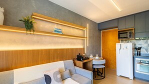 Una cocina moderna con microondas integrado, refrigerador blanco y encimera de madera.