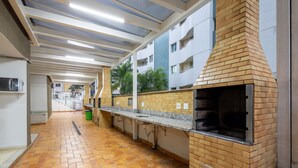 A commercial kitchen with a brick oven, stainless steel countertops, and a tiled floor. - Luxury Penthouse w/ Jacuzzi in Brasilia Bcy2001 (Águas Claras)