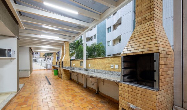 A commercial kitchen with a brick oven, stainless steel countertops, and a tiled floor. - Luxury Penthouse w/ Jacuzzi in Brasilia Bcy2001 (Águas Claras)