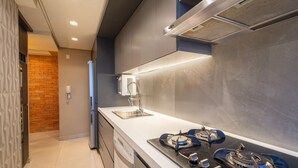 A modern kitchen with a stainless steel sink, a gas stove, and a built-in oven. - Luxury Penthouse w/ Jacuzzi in Brasilia Bcy2001 (Águas Claras)