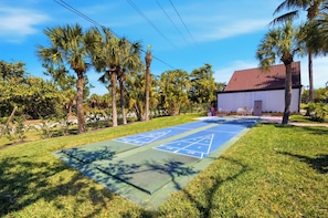 A shuffleboard court with a house in the background. - 🌺Loggerhead Cay 184 🐬Gulf and pool view!🌟 (Sanibel)