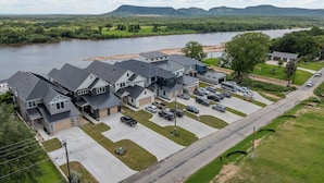 A residential area with houses, a parking lot, and a river in the background. - Sunset Oaks Estate I: Waterfront, Infinity Pool, Hot Tub & Game Room! (Kingsland)