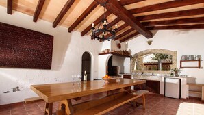 A rustic kitchen with a wooden table, a chandelier, and a stone archway. - LES PALMERES (LLEIDA). Quite and peaceful (Pollensa)