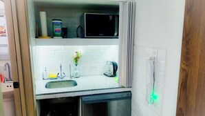 A compact kitchen with a microwave, sink, and dishwasher.