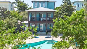 Un bâtiment à deux étages doté d’une piscine et de chaises longues.