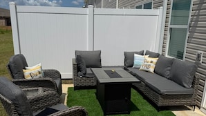 An outdoor patio with wicker furniture, a table, and a white fence. - New modern Townhouse, 3BR, 2.5B, near Mid City (Huntsville)