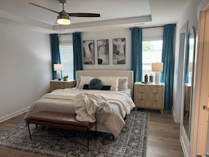 A bedroom with a bed, bench, bedside tables, and a ceiling fan. - New modern Townhouse, 3BR, 2.5B, near Mid City (Huntsville)