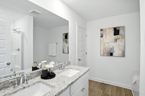A modern bathroom with two sinks, a large mirror, and a painting on the wall. - New modern Townhouse, 3BR, 2.5B, near Mid City (Huntsville)
