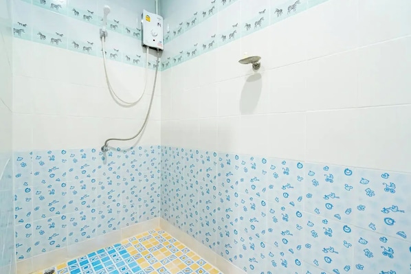 A shower area with a tiled wall featuring animal patterns, a showerhead, and a control panel. - The Palm Krabi Residence And Resort (Krabi)