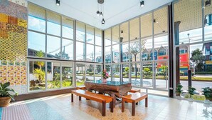 Un vestíbulo amplio con ventanas grandes, un banco de madera y una mesa de troncos.