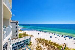 A beachfront hotel with a pool area, beach access, and a pier extending into the ocean. - Phoenix Gulf Shores Ii 1002 3 Bedroom Condo (Gulf Shores)
