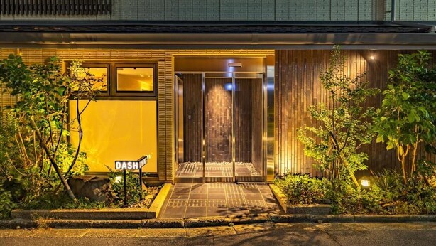 Een modern gebouw met een glazen entree, een bord waarop 