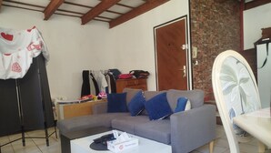 A living room with a grey sofa, a white coffee table, and a patterned rug.