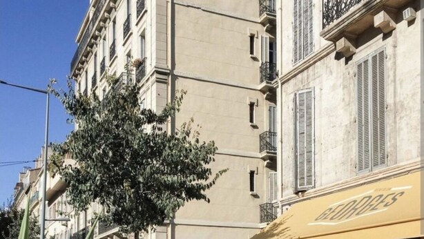 An outdoor cafe with tables and chairs, a tree, and a building with a sign that reads "GEORGES".