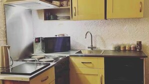 A compact kitchen with a refrigerator, microwave, stove, sink, and cabinets. - Leaf Retreat - A Rest in Nature. Pet-friendly! (Louth)