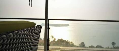 Un balcón con vista a un cuerpo de agua tranquilo y una isla distante.