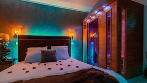A bedroom with a large bed, two bedside lamps, a wooden headboard, and a wooden cabinet with a sliding door.