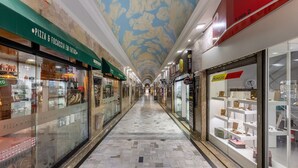 A corridor with shops on either side, including a pizza shop and a jewelry store. - Complete Studio in Curitiba Eda0001 (Curitiba)