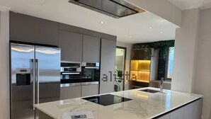 Eine moderne Küche mit einer zentralen Kochinsel, Edelstahlgeräten und einem eleganten Design.