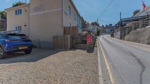 Eine Wohnstraße, auf der linken Seite ist ein blaues Auto geparkt.