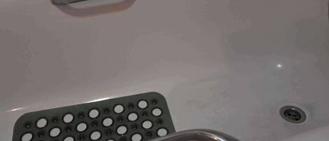 Una bañera con asiento integrado para la ducha y desagüe.