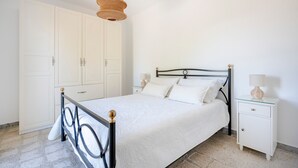 Un dormitorio con cama, mesita de noche y armario.