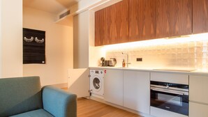 A modern kitchen with a built-in washing machine, a coffee maker, and a Siemens oven.