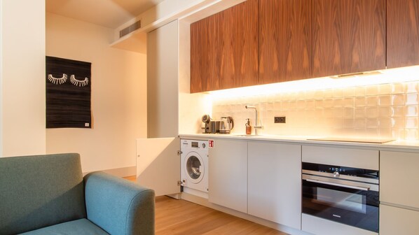 A modern kitchen with a built-in washing machine, a coffee maker, and a Siemens oven.