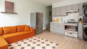 A compact kitchen with a refrigerator, oven, and washing machine.