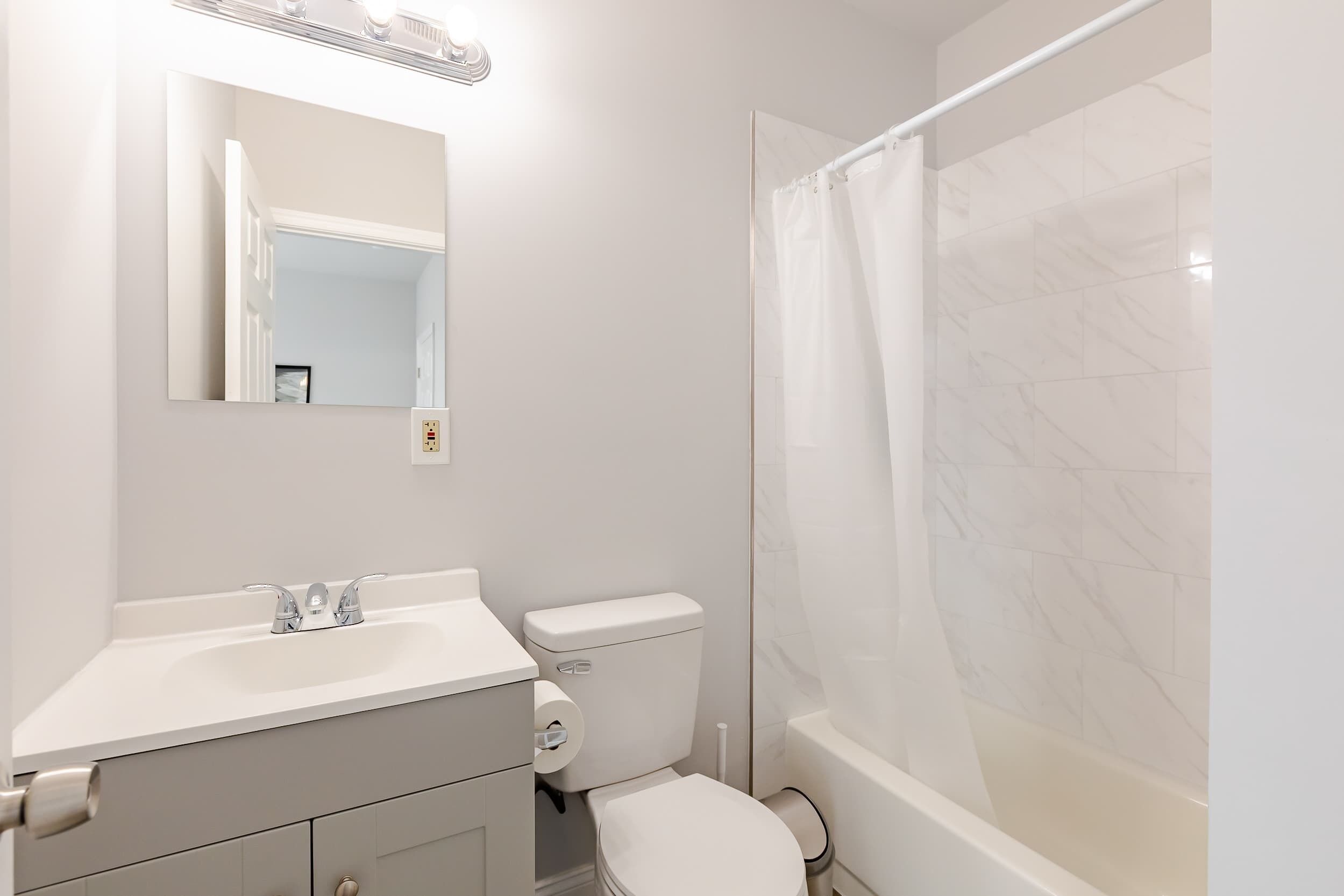 Une salle de bain comprenant des toilettes, un lavabo et un espace douche.