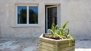 A building with a window and a planter box with plants. - Holiday Home 'Glycine' in Paimpol with Private Kitchen, Air Conditioning, and Bike Storage (Paimpol)
