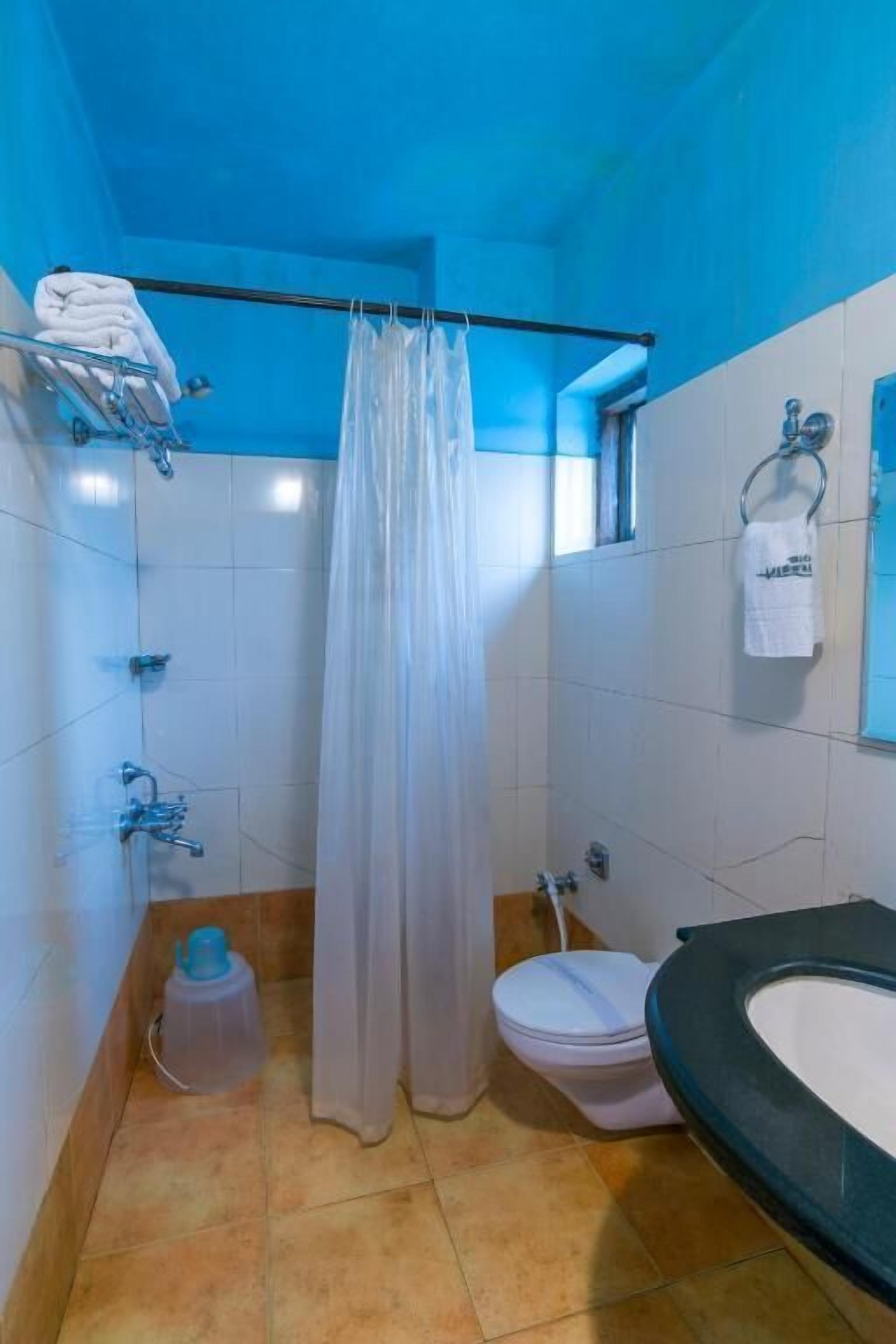 Un baño con ducha, inodoro y lavamanos.