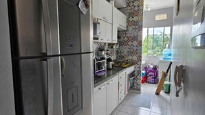 A modern kitchen with stainless steel appliances, white cabinets, and patterned backsplash. - COP30 Apartment - Total Life Condominium (Tenoné Belém)