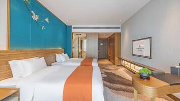 A hotel room with a large bed, a desk, and a view of the hallway.
