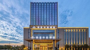 A modern hotel with a prominent vertical facade and illuminated signage. - Changde Licheng Huating Hotel (Changde)
